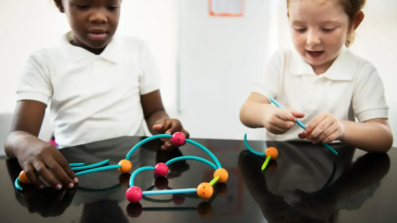 Bambini impegnati in attività sensoriali, costruendo con forme colorate.