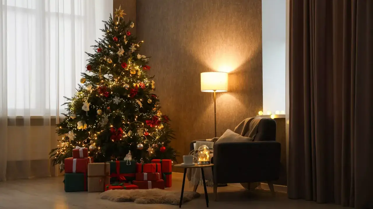 Un albero di Natale addobbato con luci e palline, circondato da regali. Un'atmosfera calda e accogliente, perfetta per capire come si fa l'albero di natale.