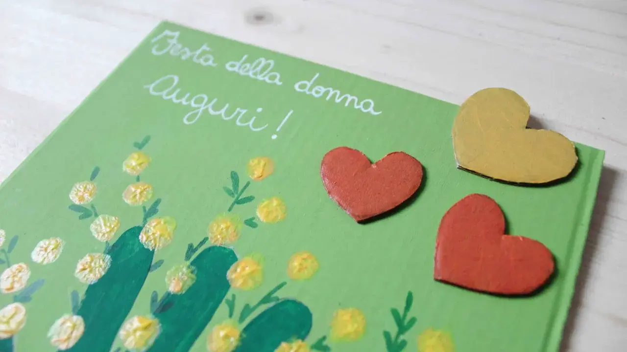Biglietto fai da te per la Festa della Donna con mimose dipinte e cuori. Idee creative per un augurio speciale.
