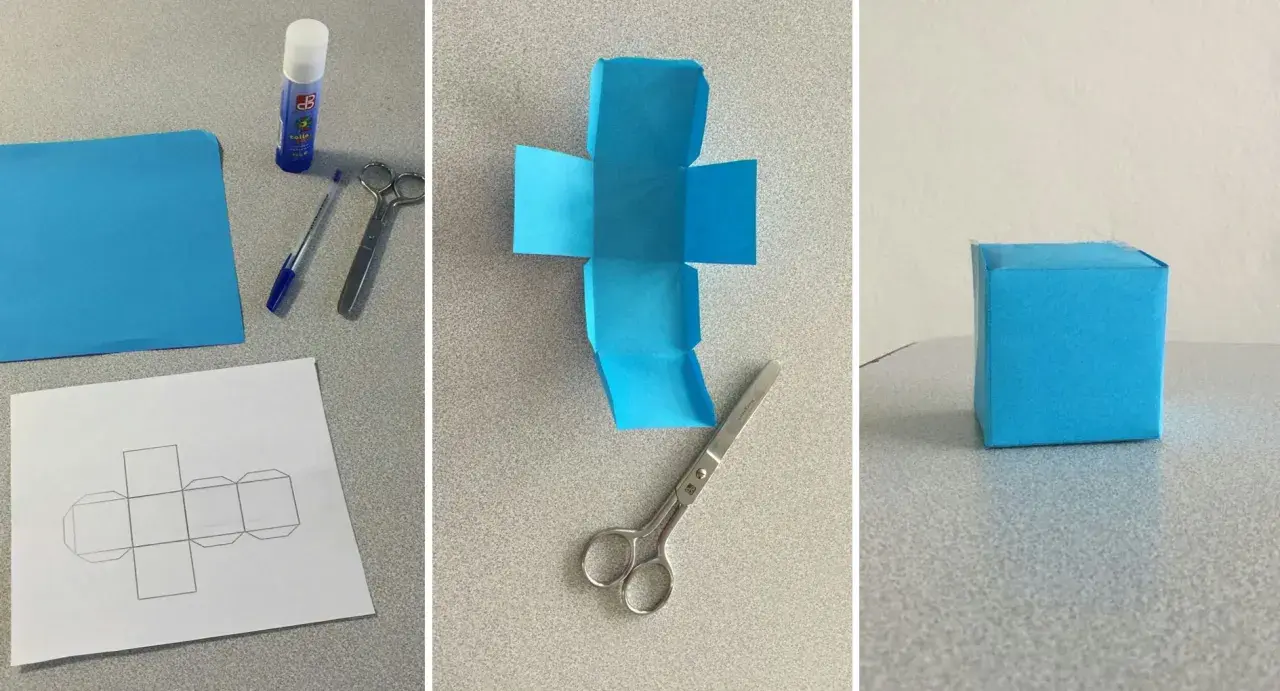 Creazione di un cubo fai da te: carta blu, forbici, colla e modello per un progetto creativo.