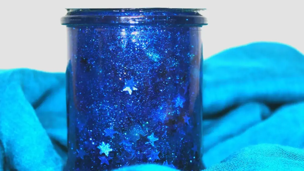 Barattolo della calma fai da te con glitter blu e stelline, un piccolo universo scintillante per rilassarsi.