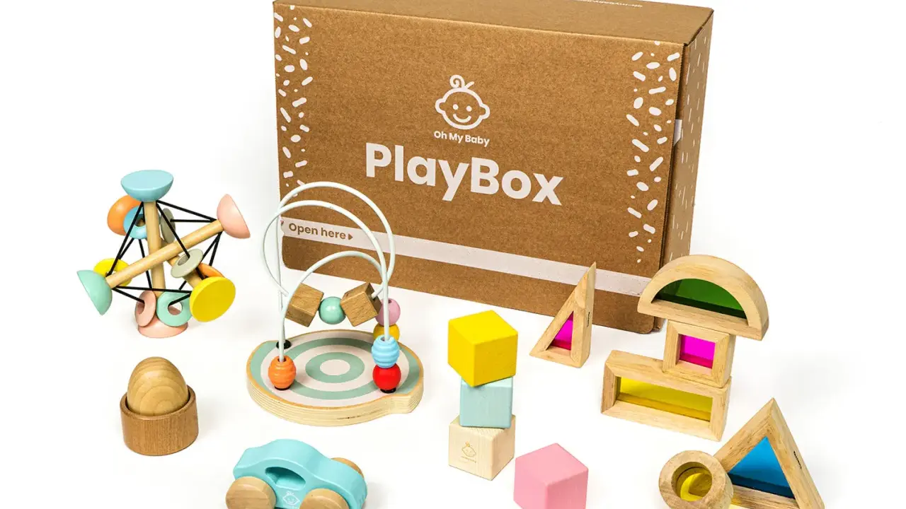 Scatola PlayBox con giochi di precisione in legno: macchinina, abaco, blocchi colorati e forme trasparenti per stimolare la creatività.