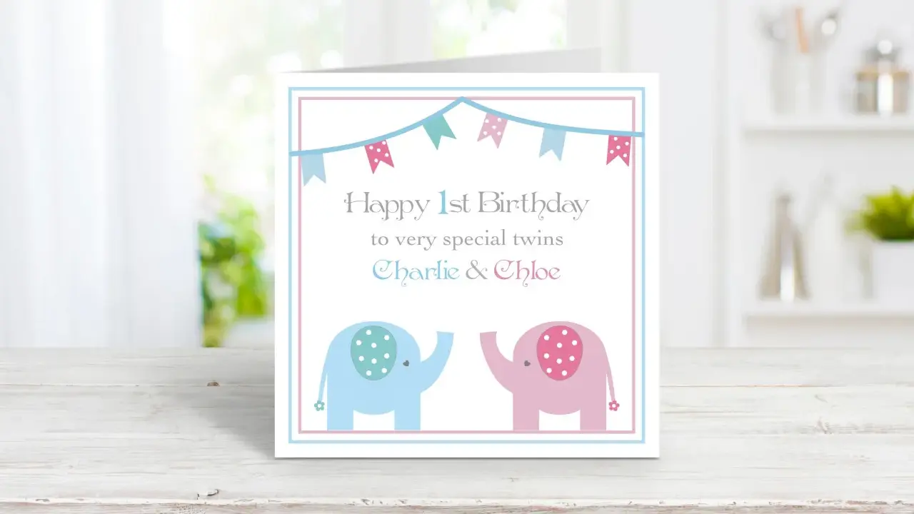 Biglietto di auguri per il doppio buon compleanno gemelli, con elefanti rosa e azzurri e festoni.