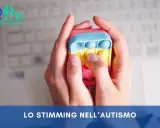 Mani che premono un giocattolo pop-it colorato, un esempio di stimming cos'è, utile per l'autismo.