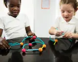 Bambini impegnati in attività sensoriali, costruendo con forme colorate.