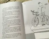 Un libro con testo e un disegno di un ragazzo su una bicicletta, perfetto per racconti divertenti brevi.
