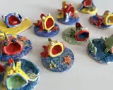 Piccoli pesci colorati, realizzati con la creta, con bocche spalancate e occhi sporgenti, sembrano nuotare in un mare di ceramica.