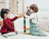 Bambini di 4 anni giocano con blocchi colorati e animali di legno, un'attività divertente e creativa.