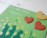 Biglietto fai da te per la Festa della Donna con mimose dipinte e cuori. Idee creative per un augurio speciale.