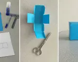 Creazione di un cubo fai da te: carta blu, forbici, colla e modello per un progetto creativo.