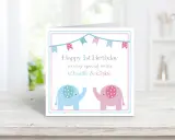 Biglietto di auguri per il doppio buon compleanno gemelli, con elefanti rosa e azzurri e festoni.