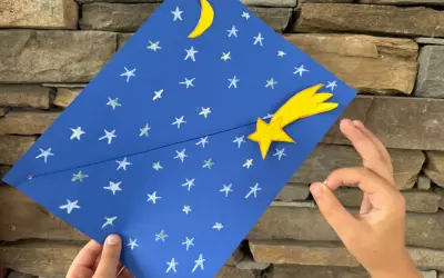 Un cielo blu con stelle e luna, una stella cometa gialla. Un lavoretto per bambini, stella di natale.