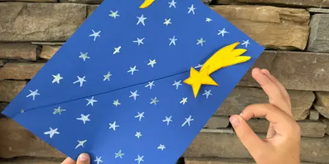 Un cielo blu con stelle e luna, una stella cometa gialla. Un lavoretto per bambini, stella di natale.