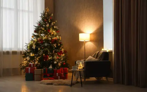 Un albero di Natale addobbato con luci e palline, circondato da regali. Un'atmosfera calda e accogliente, perfetta per capire come si fa l'albero di natale.