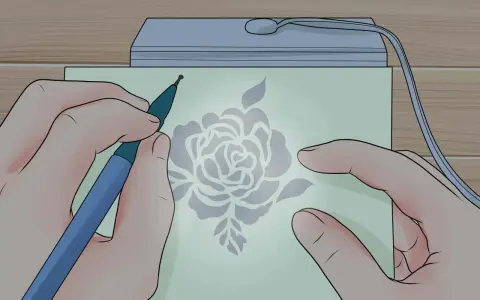 Mani che creano un disegno floreale con uno strumento su carta illuminata, un'arte di embossing su carta.