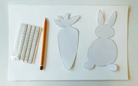 Sagoma di coniglietto e carota, matita e adesivi per creare decorazioni pasquali.