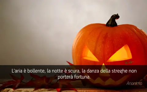 Zucca di Halloween illuminata, con foglie rosse e una citazione: "L'aria è bollente, la notte è scura, la danza della streghe non porterà fortuna." Perfetta per frasi di Halloween per bambini.