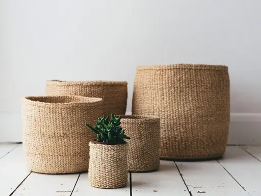 Ceste di vimini di varie dimensioni, una con una piantina. Idee per come abbellire una cesta di vimini con stile naturale.