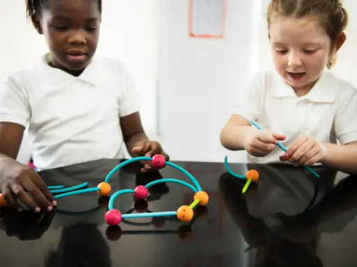 Bambini impegnati in attività sensoriali, costruendo con forme colorate.