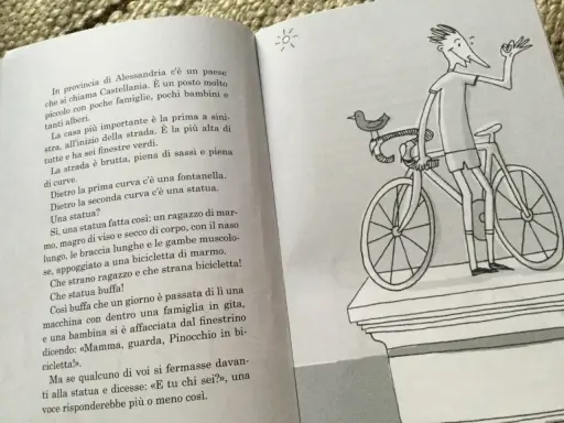 Un libro con testo e un disegno di un ragazzo su una bicicletta, perfetto per racconti divertenti brevi.