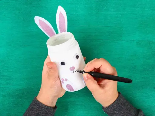 Mani creano un coniglietto pasquale con un barattolo, uno dei lavoretti di Pasqua bellissimi.