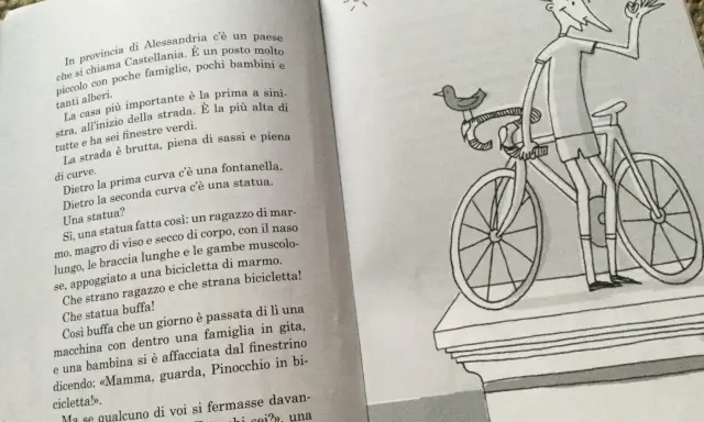Un libro con testo e un disegno di un ragazzo su una bicicletta, perfetto per racconti divertenti brevi.