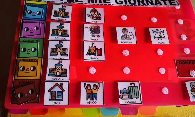Un'agenda visiva per l'autismo con icone per scuola, sport, spesa, medico, parco, festa, casa, amici e viaggio.