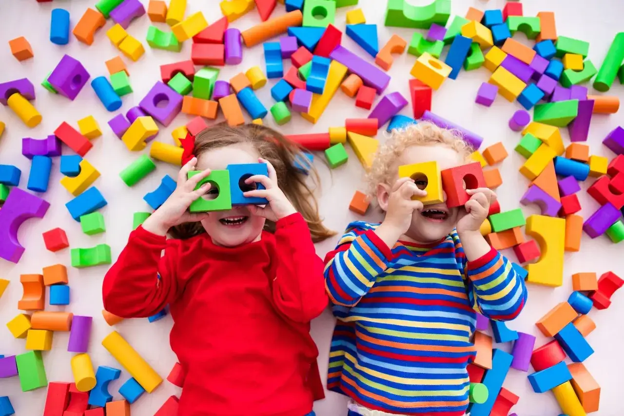 Bambini felici con blocchi colorati, perfetti giochi per bambini iperattivi.
