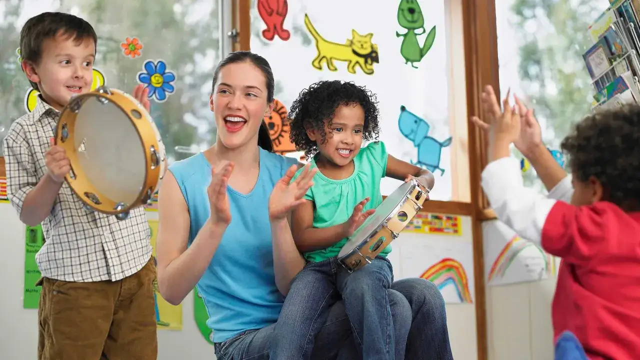 Bambini e maestra giocano con tamburelli, esempi di musicoterapia in azione.