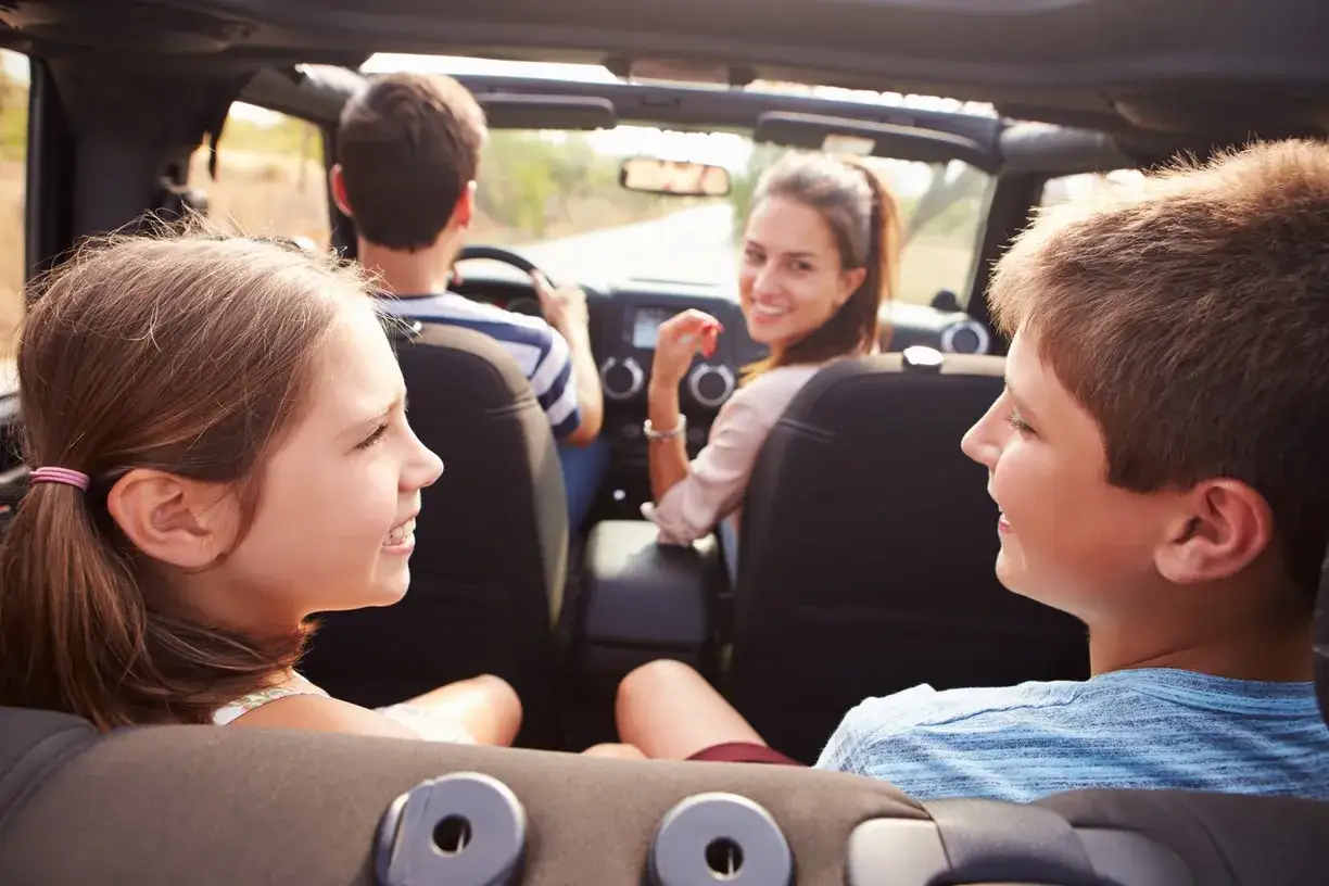 Famiglia felice in auto, perfetta per idee di giochi da fare in macchina bambini.