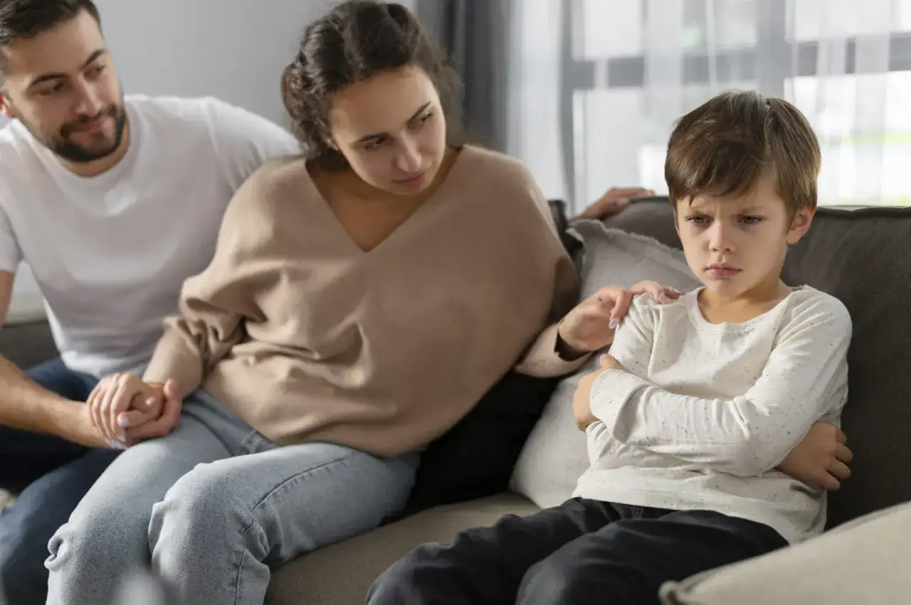 Genitori cercano di confortare il figlio arrabbiato. Momenti difficili che ricordano le vere frasi sulla maternità: amore incondizionato.