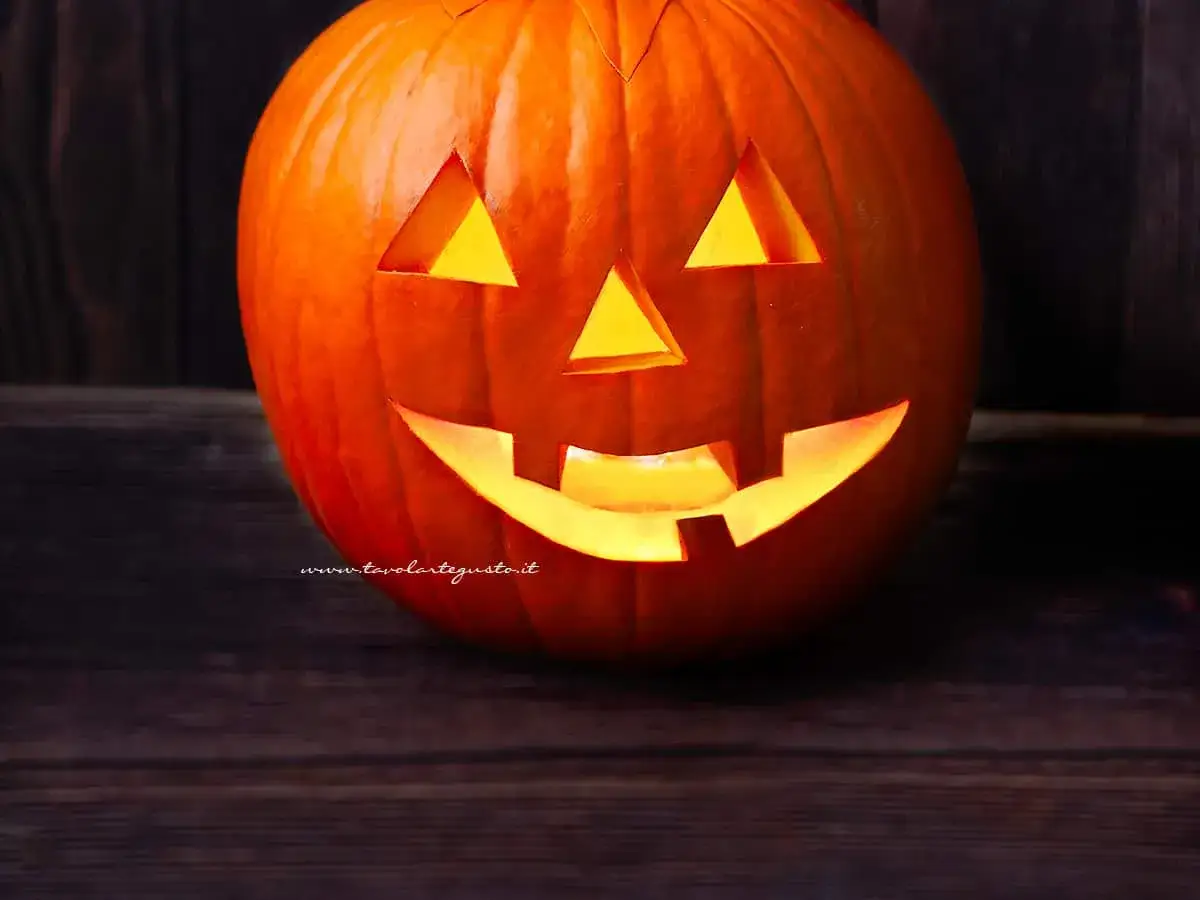 Zucca di Halloween fai da te illuminata, con un volto spaventoso intagliato. Perfetta per creare l'atmosfera giusta!