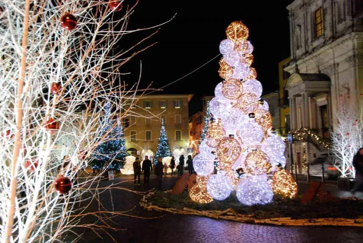 Albero di Natale luminoso, un'installazione che mostra come si fa l'albero di natale con sfere luminose bianche e dorate.