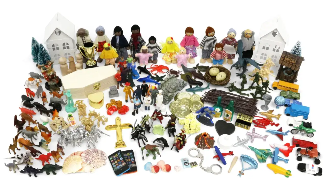 Un assortimento di miniature per sandplay therapy: case, persone, animali, veicoli, tesori e simboli.