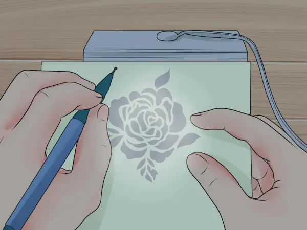 Mani che creano un disegno floreale con uno strumento su carta illuminata, un'arte di embossing su carta.