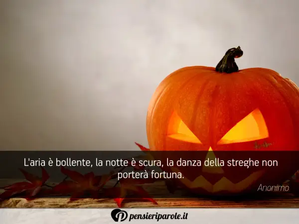 Zucca di Halloween illuminata, con foglie rosse e una citazione: "L'aria è bollente, la notte è scura, la danza della streghe non porterà fortuna." Perfetta per frasi di Halloween per bambini.